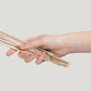 hand holding addition studio australian native incense - An all in one designer incense set which includes brass holder, ash catcher and 15 Incense Sticks. Simply flip the lid & insert the solid piece into it. Light your incense and rest it vertically within the hole. Commence Relaxation. - juniper berry & frankincense